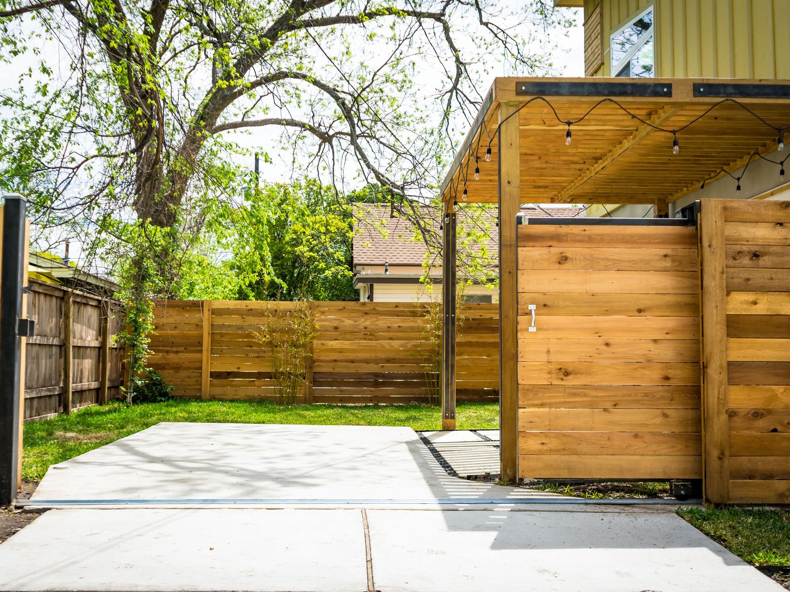 Horizontal cedar privacy fence with a matching cedar slide gate over a concrete drive