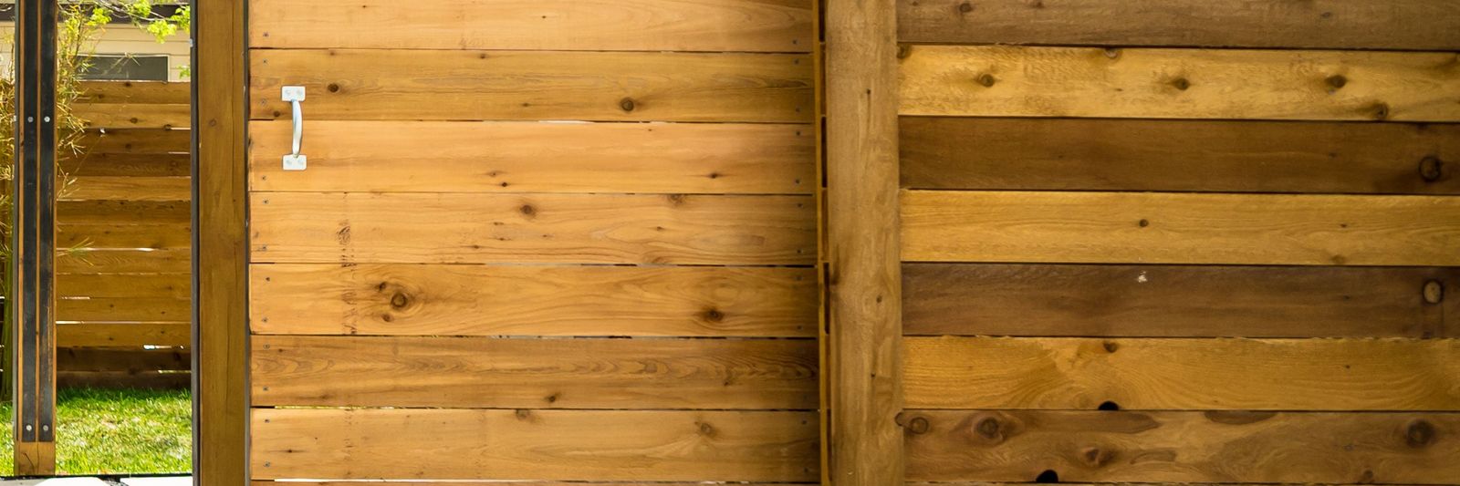 Horizontal cedar privacy fence with a matching cedar gate, framed on steel posts